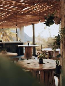 a patio with tables and potted plants in a building at BaraBara Eat&Sleep - Eco Boutique Hotel in Paje