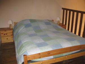 - un lit avec une couverture bleue et verte dans l'établissement Gîte Mas des cabanes en petite camargue, à Aimargues