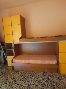 a bedroom with two bunk beds and yellow cabinets at Casa Vacanza Giacu in Arzana