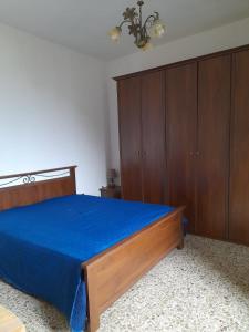 una camera con letto blu e armadi in legno di Casa Vacanza Giacu ad Arzana
