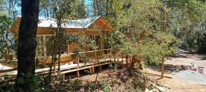 a cabin in the woods with a wooden deck at Cabañas el Mirador in Recinto