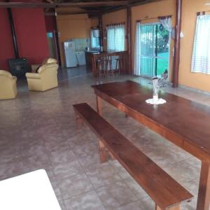 Quinta Los Sauces في سان نيكولاس دي لوس أرويوس: غرفة معيشة مع طاولة خشبية وأريكة