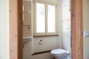 a bathroom with a toilet and a window at Villa Cartoceto in Cartoceto