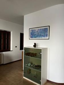 ザンブローネにあるCasa Morelloの壁に絵が描かれた部屋のガラス張りのキャビネット