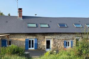 Casa de piedra con puertas y ventanas azules en Maison de Charme 4 chambres, en Les Moutiers-en-Cinglais