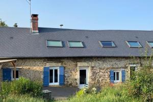 a stone house with blue doors and windows at Maison de Charme 4 chambres in Les Moutiers-en-Cinglais