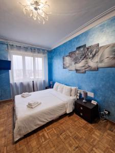 1 dormitorio con 1 cama grande y paredes azules en Torino Panoramic view Apartment, en Turín