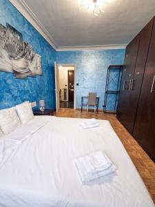 um quarto com uma grande cama branca com paredes azuis em Torino Panoramic view Apartment em Turim