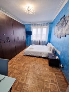 um quarto com paredes azuis, uma cama e uma mesa em Torino Panoramic view Apartment em Turim