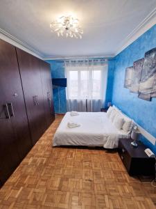 1 dormitorio con paredes azules, 1 cama y lámpara de araña en Torino Panoramic view Apartment, en Turín