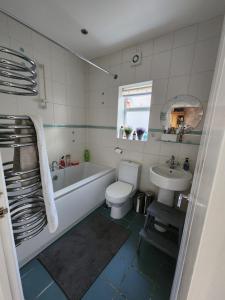 a bathroom with a tub and a toilet and a sink at Countryside Home in London in Shirley