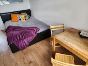 - une petite chambre avec un lit et une table en bois dans l'établissement Countryside Home in London, à Shirley