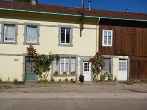 uma casa com flores em frente em Ferme du Haut Barba em Liézey