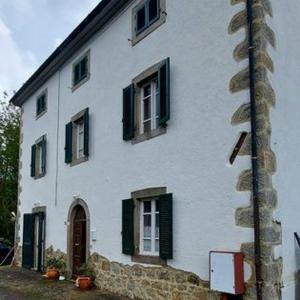 a white house with green shuttered windows on it at Antica Dimora in Bagnore