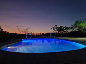 una gran piscina azul en un patio por la noche en JFM Apartamento, en Coco