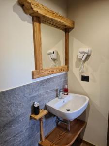 ein Badezimmer mit einem weißen Waschbecken und einem Spiegel in der Unterkunft La Maison. Il Nido dell'Aquila in Bardonecchia