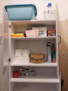 a white cabinet filled with towels and other kitchen items at Casa Alessandra in Aulla +1 photo