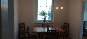 a dining room table with chairs and a window at Prestige Citycenter Appartment mit Terrasse in Detmold