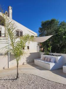 a patio with a couch and a palm tree at Villa Rosa in Bari Sardo