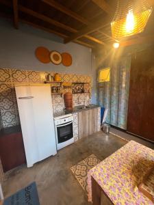 a kitchen with a white refrigerator and a stove at Casinhas no Contêiner dos Cristais in Delfinópolis