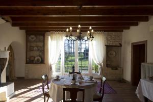 a dining room with a table and a large window at La Bribaudonnière in Saint-Palais-de-Phiolin