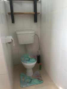 a bathroom with a toilet with a rug on the floor at Bedroom Diani Beach in Junda