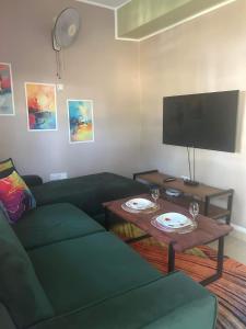 - un salon avec un canapé et une table avec des verres à vin dans l'établissement Bedroom Diani Beach, à Junda
