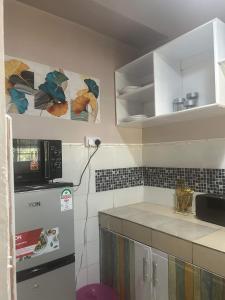 La cuisine est équipée d'un réfrigérateur et d'un four micro-ondes. dans l'établissement Bedroom Diani Beach, à Junda