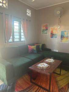 uma sala de estar com um sofá verde e uma mesa em Bedroom Diani Beach em Junda