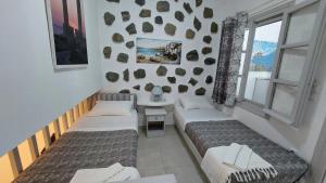 ナクソス・コラにあるAzzurro Naxos, Azzurro I - Azzurro II - Azzurro IIIのベッド2台と窓が備わる客室です。