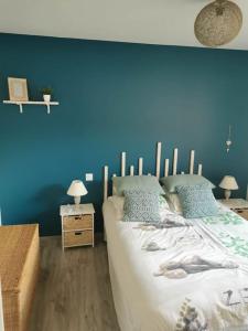 una camera da letto con una parete blu e un letto di chez Rod a Cajarc