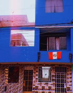 un bâtiment bleu avec un drapeau devant lui dans l'établissement Inti Hostel Airport, à Lima