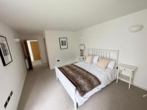 a white bedroom with a bed and a table at Central London Luxury 4 Bed Home in London