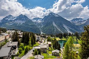 eine Luftansicht einer Stadt mit See und Bergen in der Unterkunft Pension Arosa - Self Check-In in Arosa