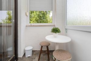 a small white table and two stools in a room at Apartments Patar in Grabovac