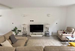 a living room with two couches and a flat screen tv at Central London Luxury 4 Bed Home in London