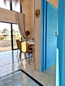a room with a table and chairs and a blue door at Lulu Holiday Resort in Mielno