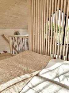 1 dormitorio con 1 cama con pared de madera en Lulu Holiday Resort en Mielno