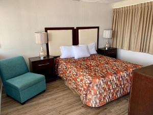 Habitación de hotel con cama y silla en Cabana Motel, en Ocean City