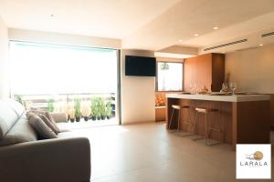 a living room with a couch and a kitchen at Larala 02 - Nuevo apartamento en la playa del Arenal con vistas al mar in Jávea