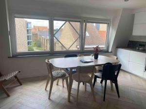 Una cocina con una mesa y sillas en una habitación. en Appart De Pauw Nieuport, en Nieuwpoort