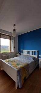 a bedroom with a large bed with a blue wall at Ti Racconto di un Sogno Rooms - Cielo & Terra in Chianciano Terme