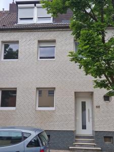 a house with a car parked in front of it at Capital Apartments in Düren - Eifel