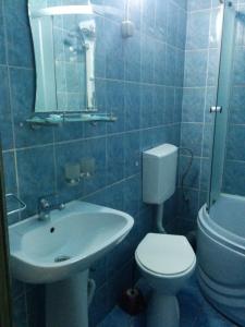 a blue tiled bathroom with a toilet and a sink at Pensiunea Casa Raul in Cluj-Napoca