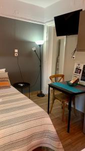 une chambre avec un lit, une table et une lampe dans l'établissement MAMA apt & parking, à Larissa