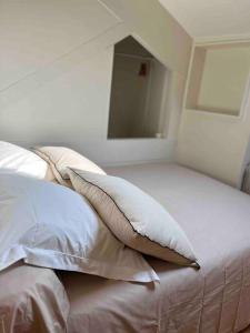 a bed with white sheets and pillows in a bedroom at Duplex bord de mer La Madrague in Marseille