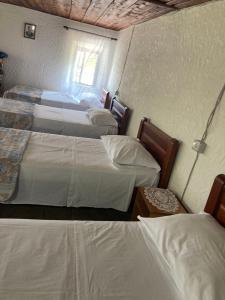 um quarto com 3 camas e uma janela em Kulla e Sadri Lukes em Theth
