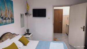 a bedroom with a bed and a tv on the wall at Pejovic Guest House in Sutomore
