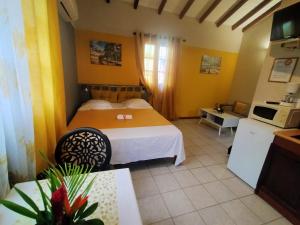 ein Hotelzimmer mit einem Bett und einer Küche in der Unterkunft ISK LOCATION in Sainte-Rose