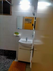 ein Bad mit einem Waschbecken und einem Spiegel in der Unterkunft ISK LOCATION in Sainte-Rose